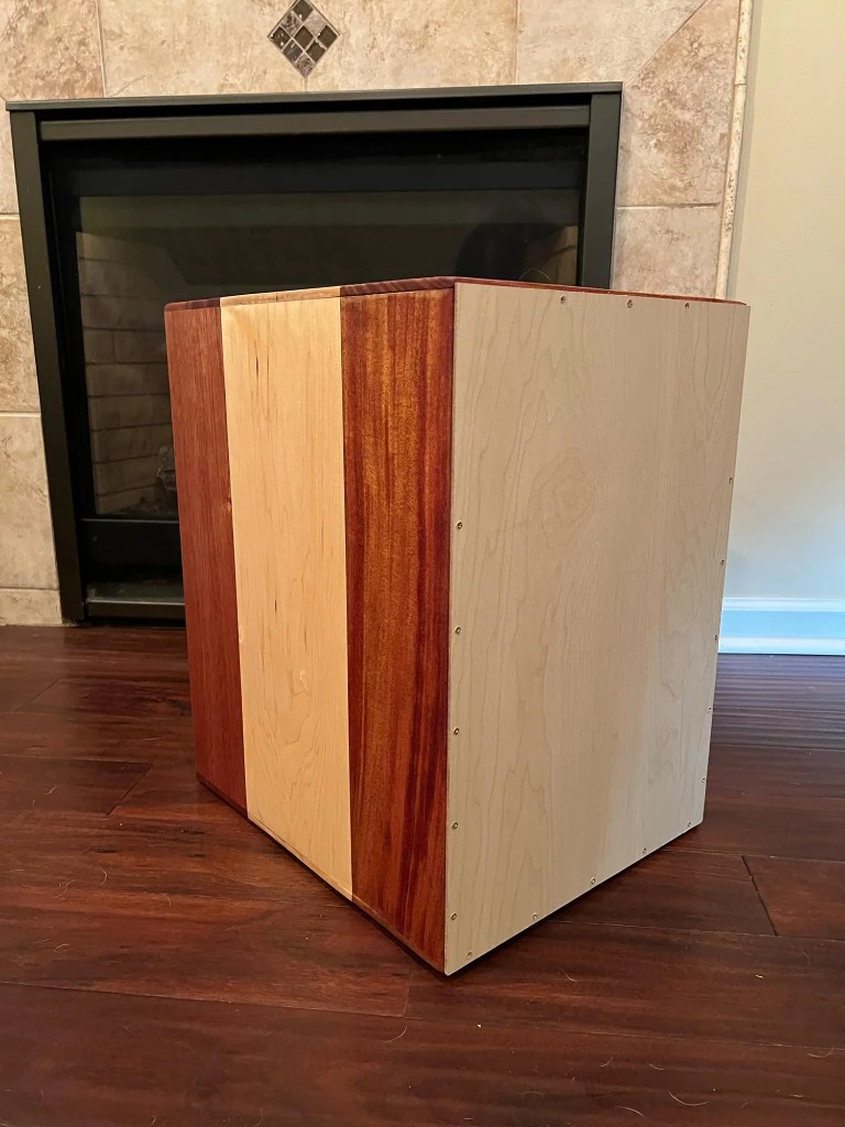 Handcrafted cajon in solid mahogany and maple with contrasting wood panels.
